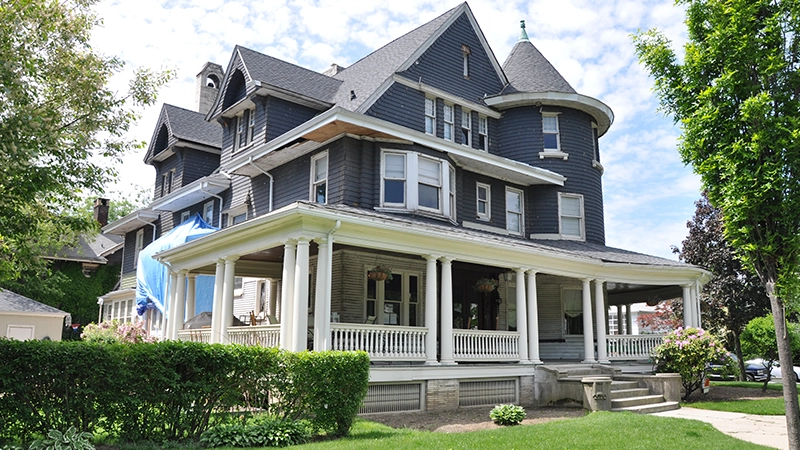 a picture of a large house with two stories high, a multi-gabled roof and a distinctive corner turret.