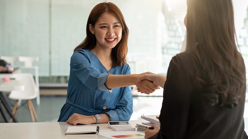 A professional handshake between two women.