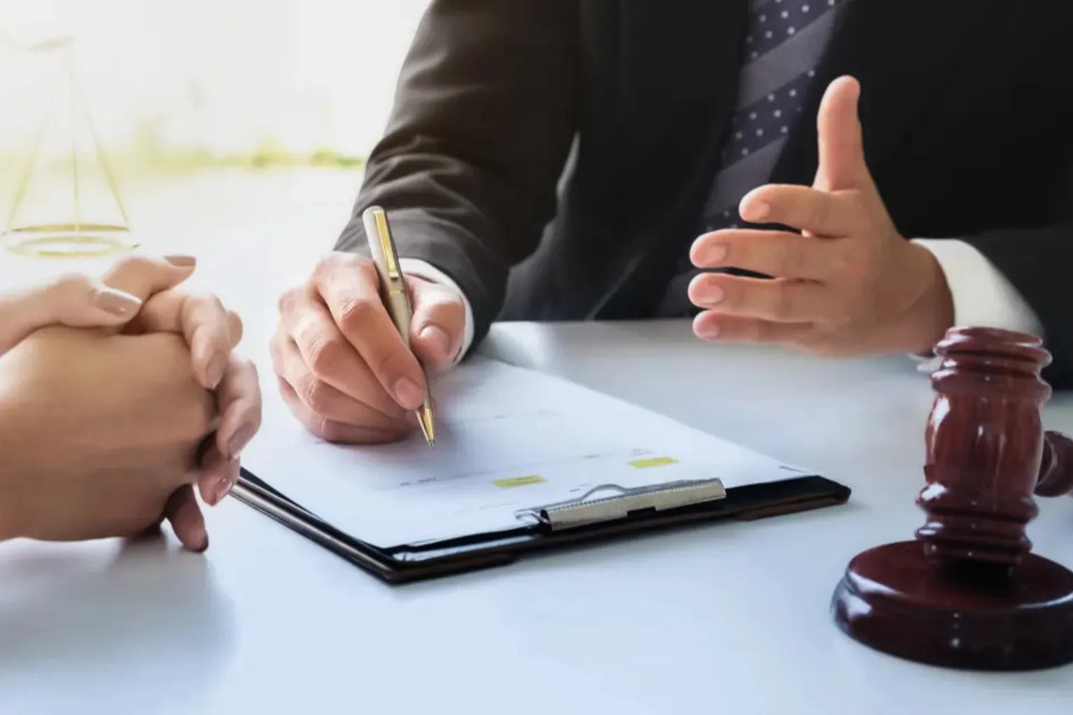 “A gavel and an attorney discussing with his client.
